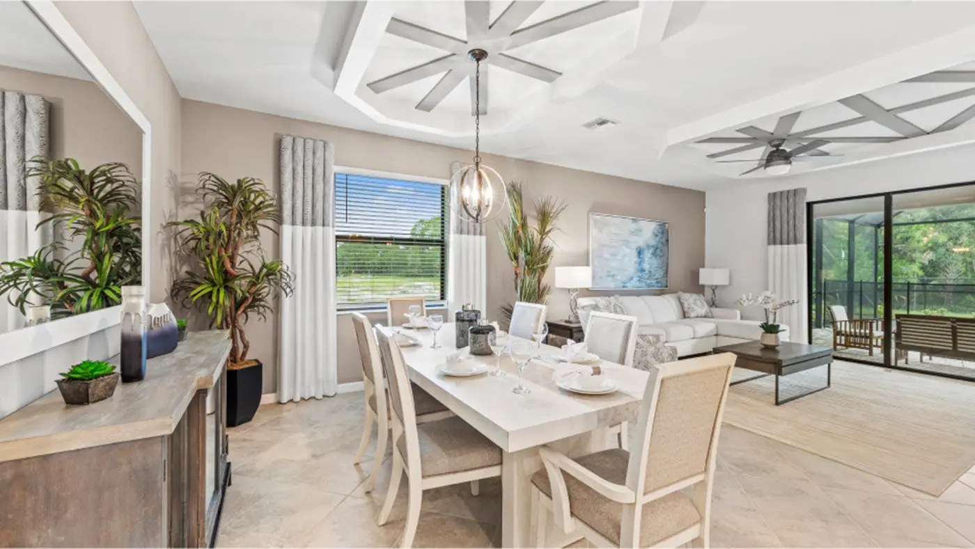 A dining room table with chairs and a couch in the background.