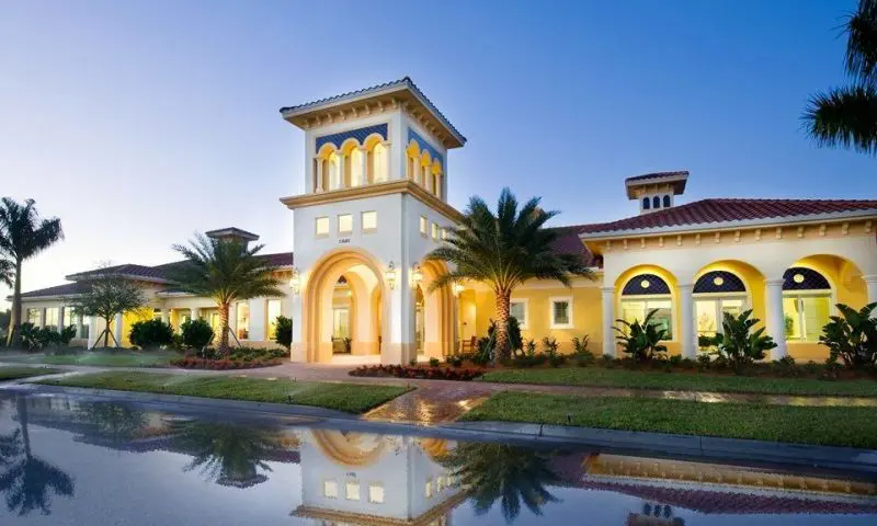 A large building with a tower and a pool in front of it.