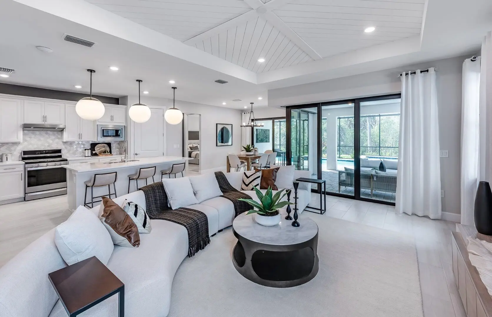 A living room with white furniture and a large open door.