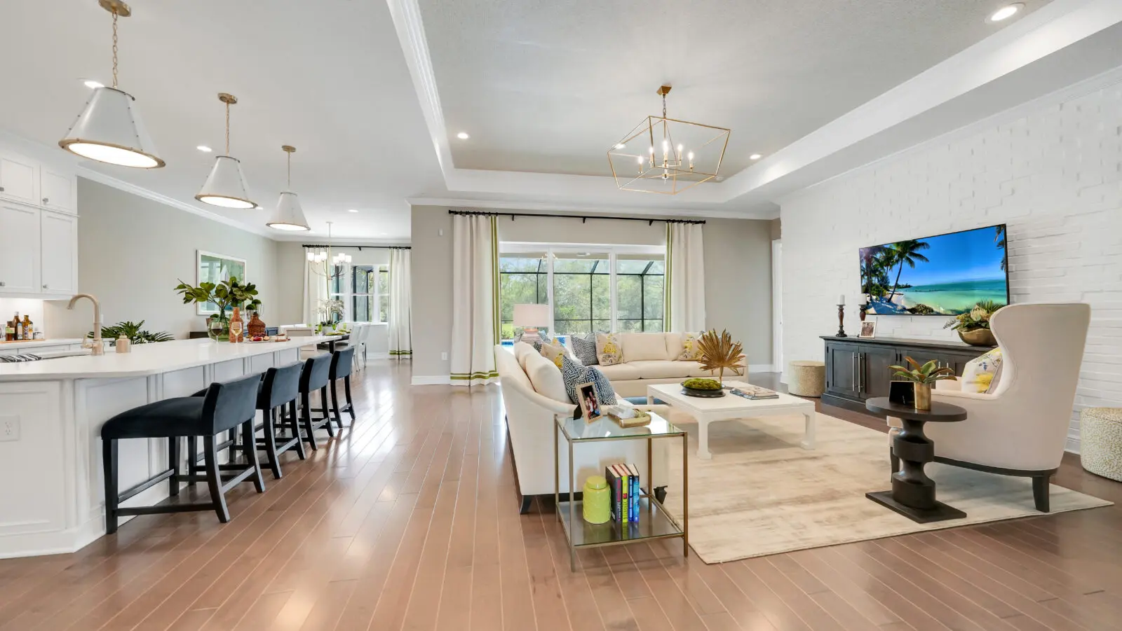 A living room with hard wood floors and white furniture.